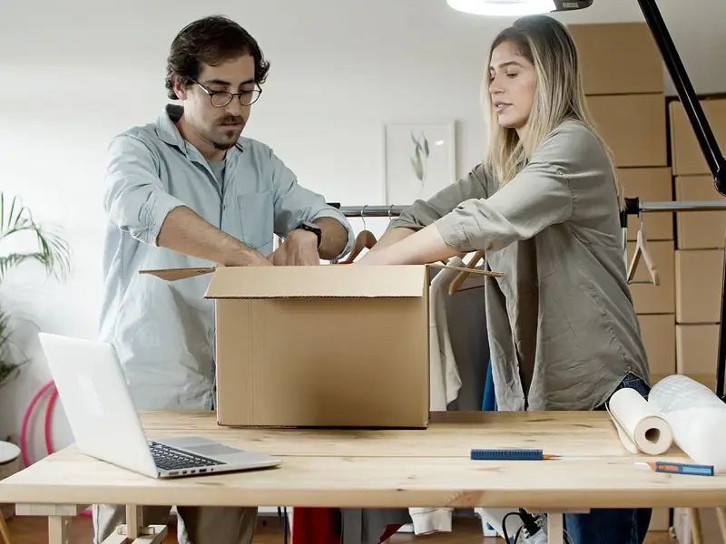 Pareja empacando productos en cajas en su pequeño negocio